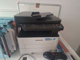 a printer sitting on top of a desk next to a laptop