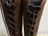 pair of brown boots with laces on them sitting on a table
