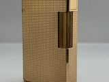 un étui à cigarettes plaqué or avec un briquet au milieu