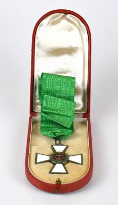 une médaille dans un écrin rouge contenant un ruban vert