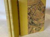 deux livres posés l'un sur l'autre sur une surface blanche