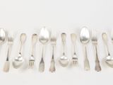 a lot of forks and spoons on a white table
