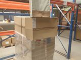 a large stack of boxes in a warehouse with pallets on the floor