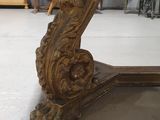 a wooden table with a carved top in the middle of a room