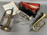 un assortiment d'instruments de musique, comprenant notamment une trompette, un étui à trompette et une trompette