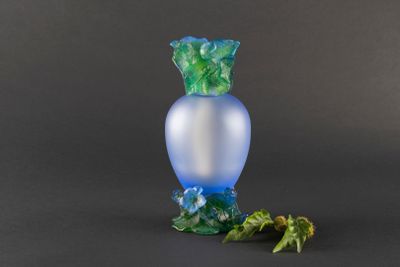 a blue vase with a green leaf on it