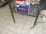 un caddie sur lequel est accrochée une affiche, dans un magasin