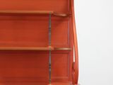 an orange cabinet with a glass door and shelves