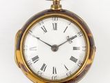 une horloge en or avec des chiffres romains sur le cadran
