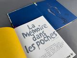 two books are open on a table with a yellow book