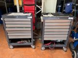 pair of metal tool carts with drawers on wheels in a garage