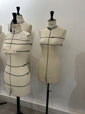 three mannequins are lined up against a wall in a room