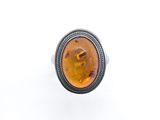 a close up of a ring with an amber stone in it