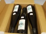 three bottles of wine in a box with a price tag