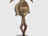 une photo d'une sculpture en bronze représentant un oiseau, posée sur un socle en bois