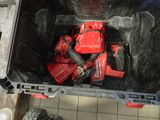 a red tool in a black container on a tiled floor