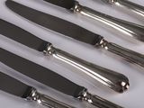 five knives on a white surface with a silver handle