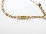 a close up of a gold bracelet with a nameplate on it