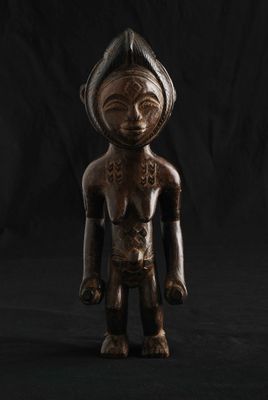 une statue en bois d'un homme avec un chapeau sur la tête