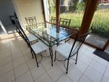 une table et des chaises en verre dans une pièce dotée d'une grande fenêtre