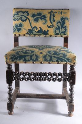 une vieille chaise en bois dont l'assise est recouverte d'un tissu bleu et jaune