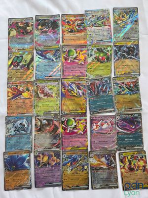 a bunch of pokemon cards sitting on top of a white sheet