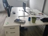 un bureau blanc sur lequel se trouvent un ordinateur portable et un téléphone portable
