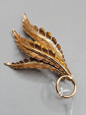 une image représentant une broche en feuille d'or sur laquelle est fixé un anneau