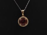 a necklace with a red stone surrounded by white diamonds