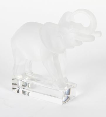 figurine d'éléphant en verre transparent posée sur un socle transparent, sur fond blanc