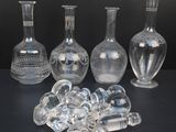 cinq vases en verre posés les uns à côté des autres sur une table