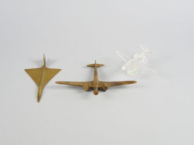 deux petits avions en laiton posés l'un à côté de l'autre sur une surface blanche