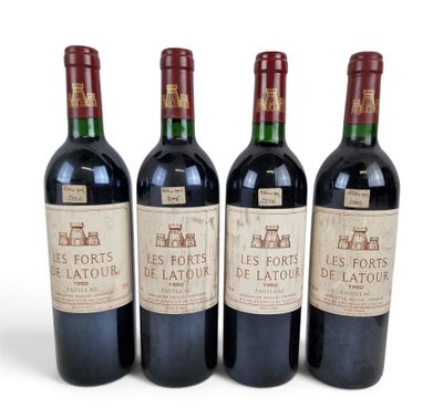 three bottles of red wine sitting next to each other on a white surface