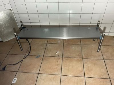 un banc en acier inoxydable au milieu d'un sol carrelé