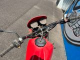une moto rouge garée sur le bord de la rue