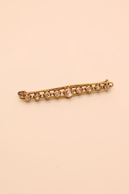 a gold and diamond bar brooch
