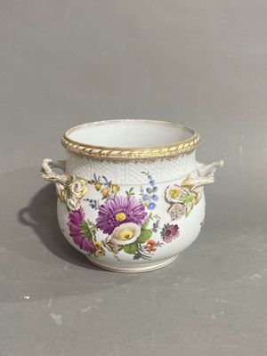 a white vase with flowers on it on a gray surface