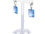 a pair of earrings with blue crystals hanging from them