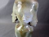 a small vase with a face on it sitting on a table