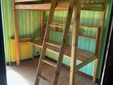 un lit superposé en bois avec une échelle dans une chambre