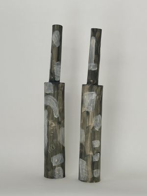 deux vases noirs et blancs posés l'un à côté de l'autre sur une surface blanche
