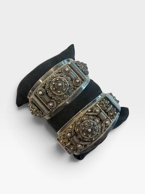 deux bracelets manchette noirs et argentés sur fond blanc