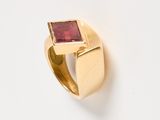 an image of a gold ring with a red stone in the middle