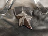 a silver star brooch on top of a black purse