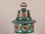 a green and white jar with a brown lid