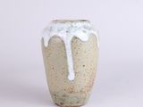 a white and brown vase with white glazes on it
