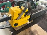 a yellow chainsaw sitting on a table in a room