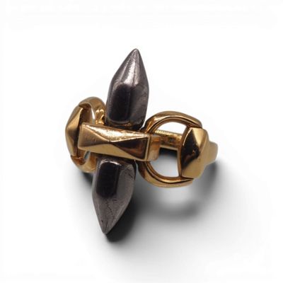 un gros plan d'une bague dorée et noire posée sur une surface blanche