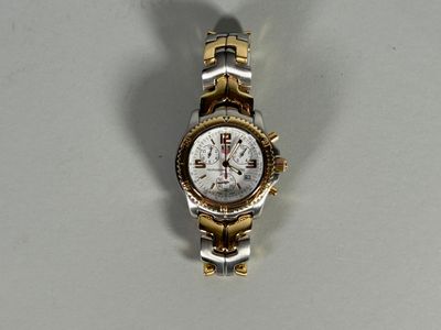 a silver and gold wrist watch on a white surface