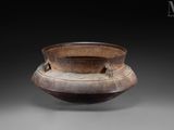 an old wooden bowl sitting on top of a table next to a black background